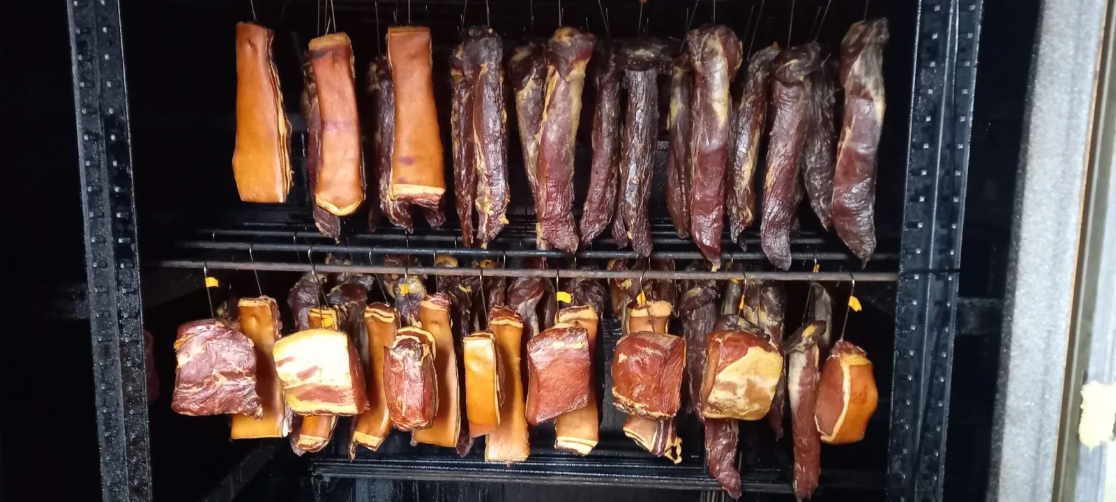Geräucherte Würste und Speck im Räucherofen